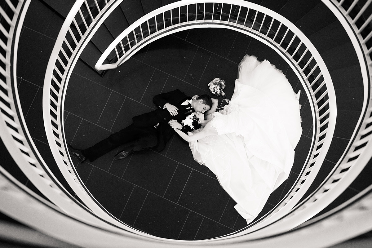 künstlerisches Hochzeitsfoto von Brautpaar in schwarz-weiß in Treppenhaus aufgenommen von Hochzeitsfotograf international bei St. Gallen Hochzeit in der Schweiz © Hochzeitsfotograf Berlin www.hochzeitslicht.de